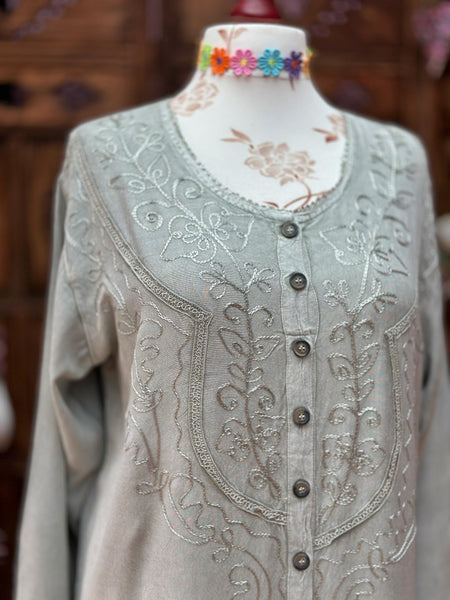 Close-up of the tonal embroidery, round neckline and button front