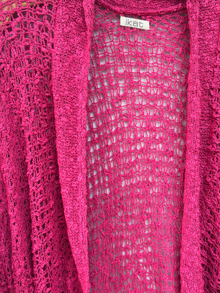 Close-up of the berry-pink open weave and textured knitted edging